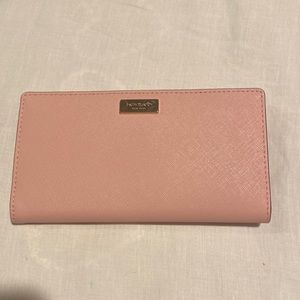 Slim, pink Kate Spade wallet. Room for cards and dollar bills and change.